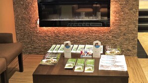 A display table with brochures and a fireplace with a stone wall backdrop. - Best Western Terrace Inn (Terrace)