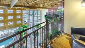 A spacious indoor area with a pool, multiple seating areas, and a view of the outside. - Ambassadeur Hotel (Québec City)
