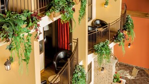 A multi-level interior with balconies, indoor seating, and hanging plants. - Ambassadeur Hotel (Québec City)
