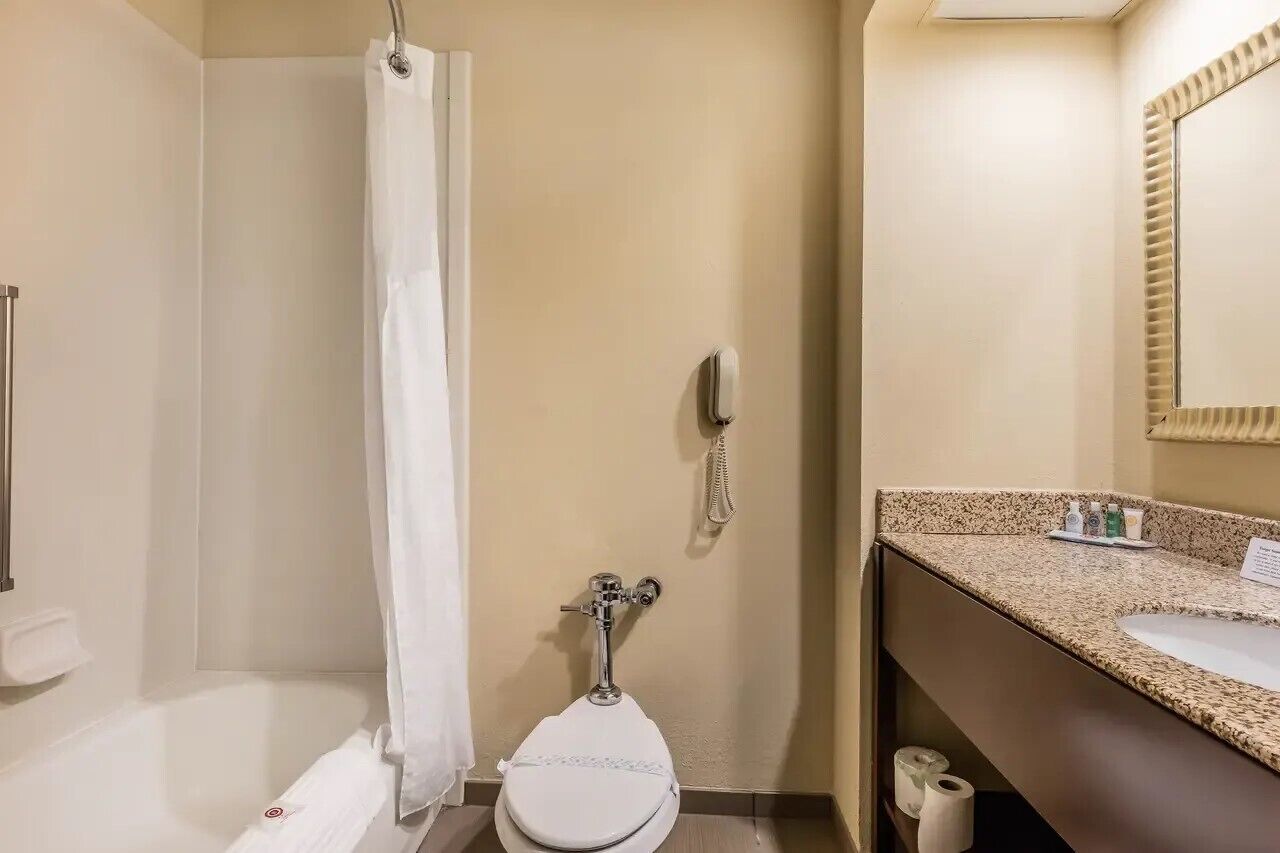 A bathroom with a shower, toilet, and sink.