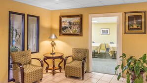 A room with two upholstered chairs, a small round table with a lamp, and framed artwork on the walls. - Quality Inn Calera I-65 exit 231 (Calera)