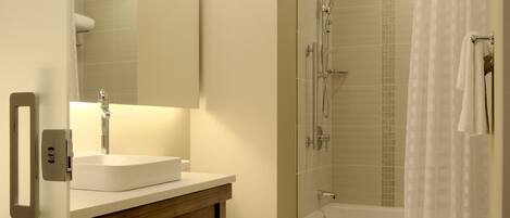A bathroom with a sink, toilet, and shower.