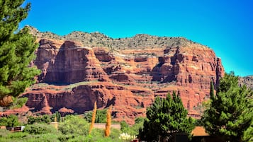 A mountainous landscape with red rock formations and green vegetation.