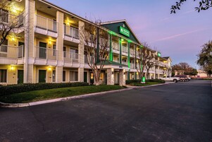 Un hotel de varios pisos con un letrero verde que indica un centro de negocios.