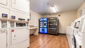 Un cuarto de lavandería con varias lavadoras, una máquina expendedora y piso de madera.