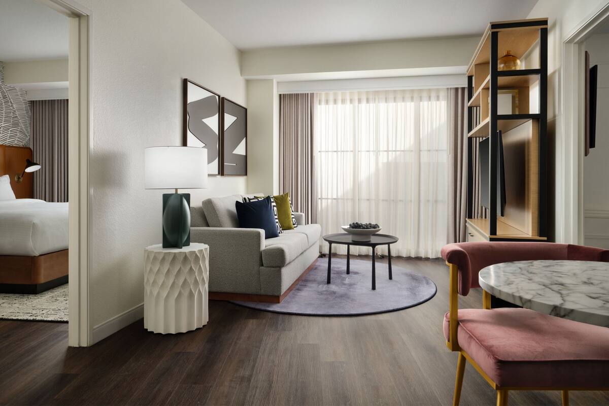 A modern living room with a sofa, a round table, and a coffee table.