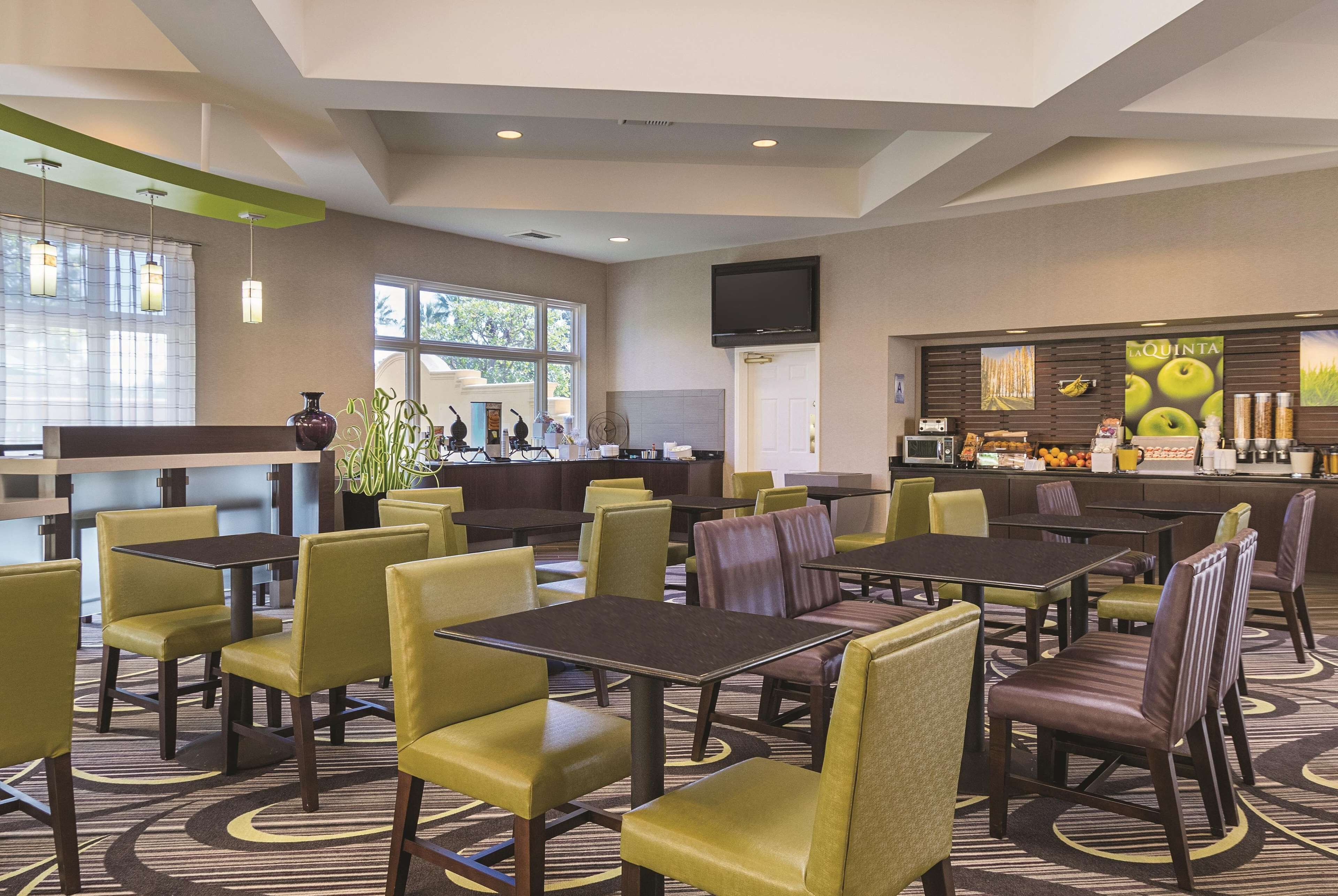 Een hotel lobby met verschillende zithoeken, een receptiebalie en een bar.