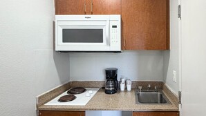 A compact kitchenette with a microwave, stove, coffee maker, and sink. - Studio 6 Rancho Cordova, CA (Rancho Cordova)
