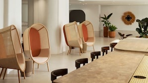 A modern dining area with a high ceiling, pendant lighting, and contemporary chairs. - Sandbourne Santa Monica, Autograph Collection (Santa Monica)