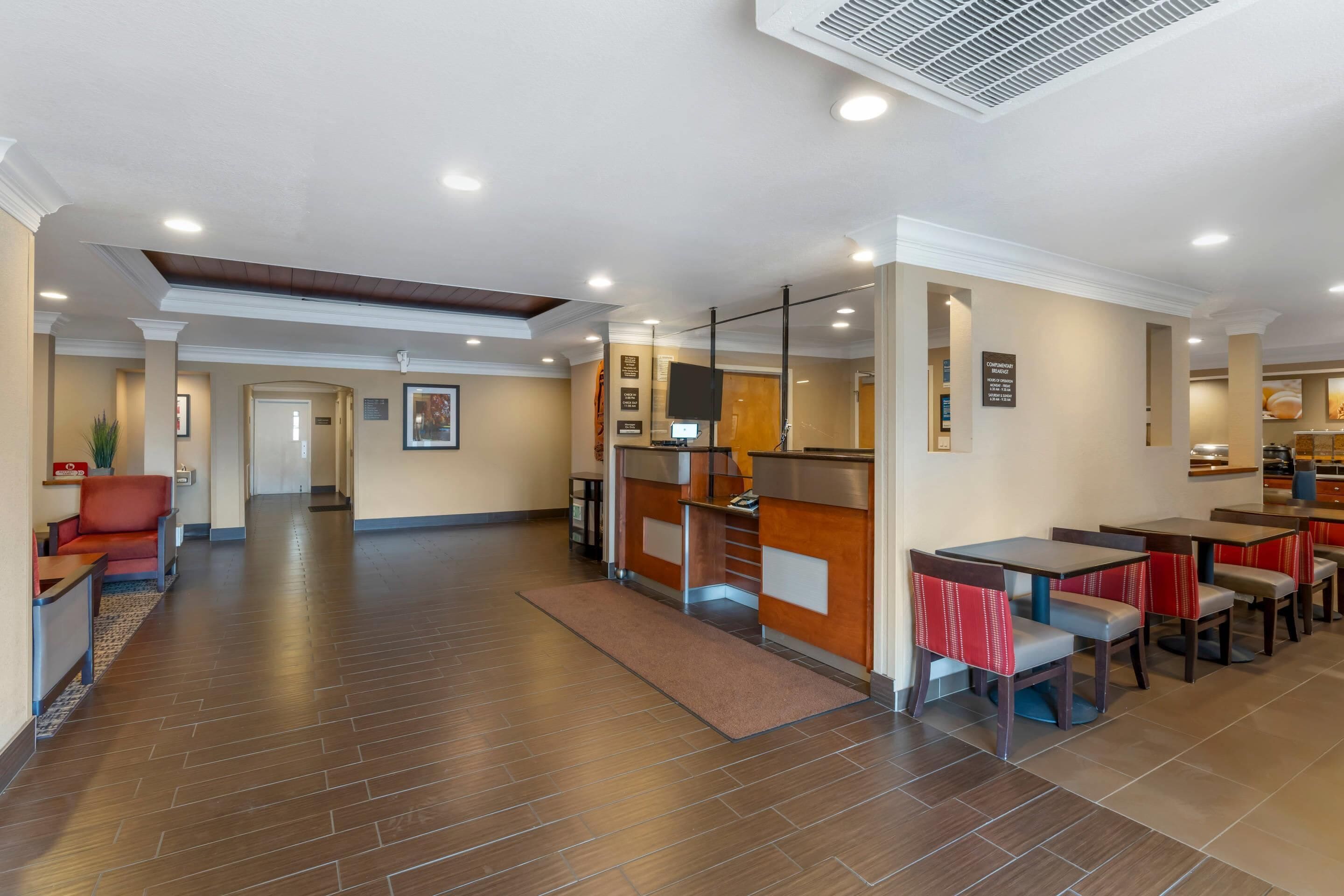 Un hall d’hôtel comprenant un comptoir d’accueil, un espace salon et un coin repas.