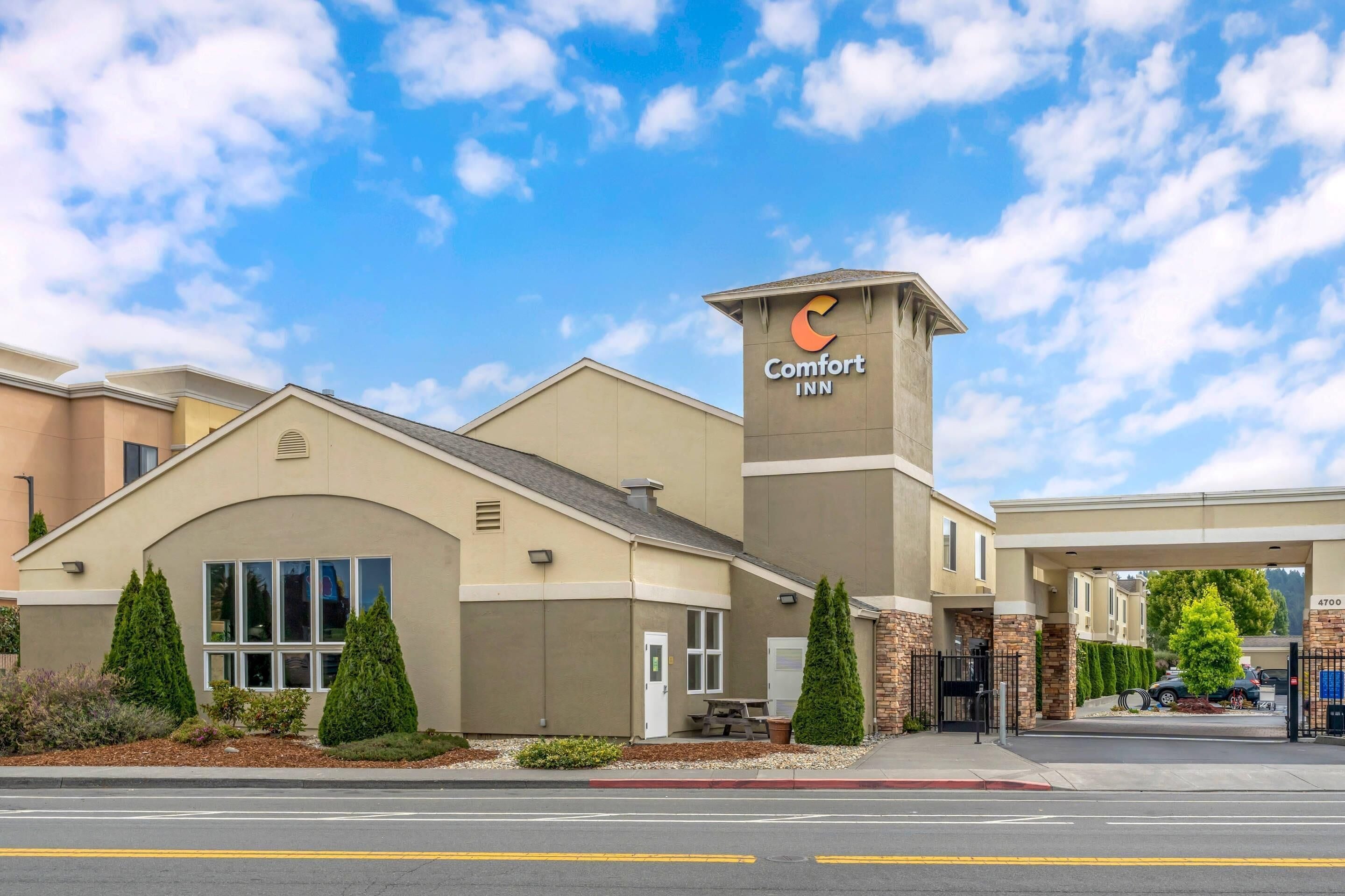 Un hotel Comfort Inn con una entrada destacada, zona de estacionamiento techada y exterior bien cuidado.