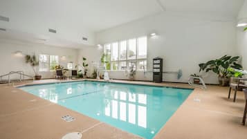 Una piscina techada, sillones reclinables de piscina