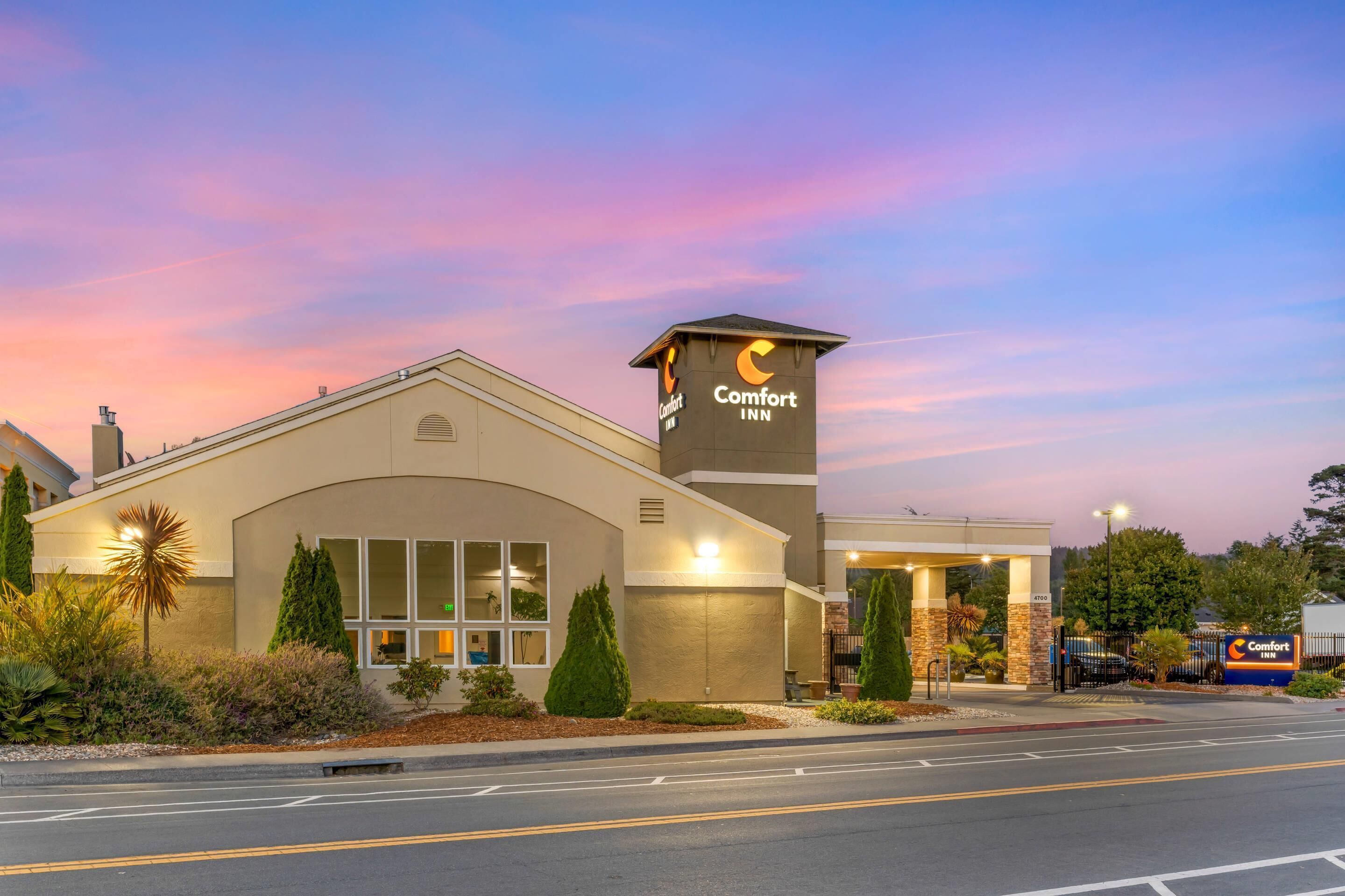 A Comfort Inn hotel with a modern design, featuring a prominent entrance and a well-lit facade.