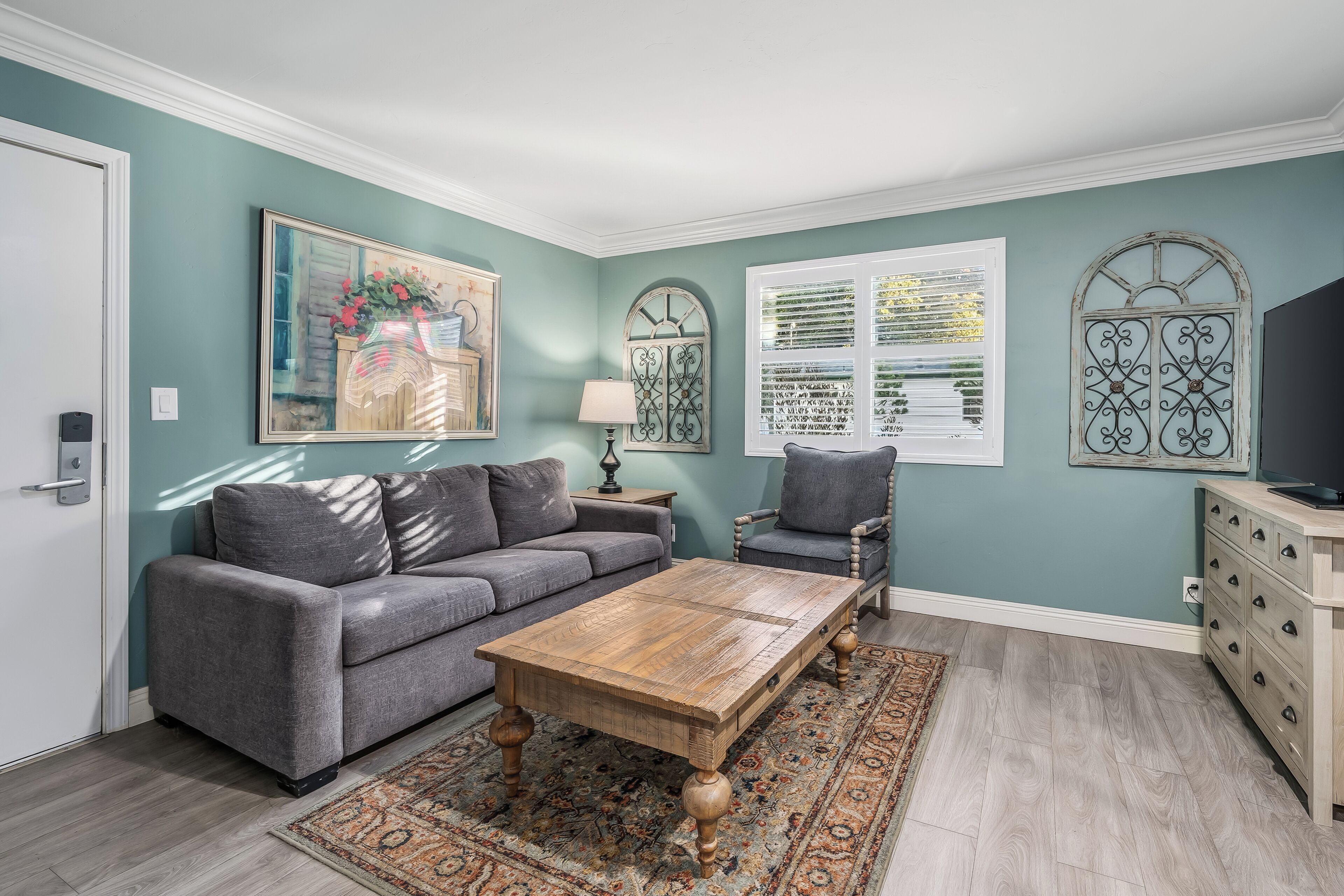 A living room with a sofa, armchair, coffee table, and decorative items.