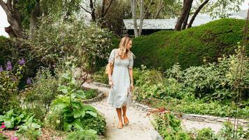 A garden pathway with lush greenery and a variety of plants.