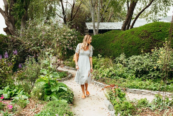 A garden pathway with lush greenery and a variety of plants.