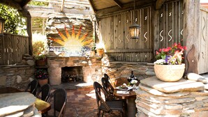 An outdoor patio with stone seating, a fire pit, and decorative plants. - Cambria Pines Lodge (Cambria)