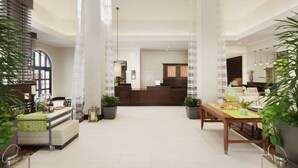 A spacious lobby with a reception desk, a dining area with a table and chairs, and potted plants. - Hilton Garden Inn Cupertino (Cupertino)