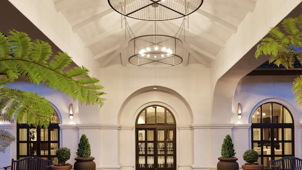 A grand entrance with a large arched doorway, a chandelier, and potted plants. - Hilton Garden Inn Cupertino (Cupertino)