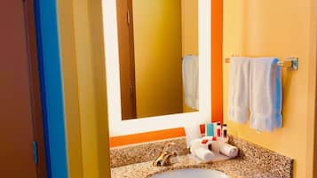 A bathroom with a granite countertop, a sink, a mirror, and a towel rack.