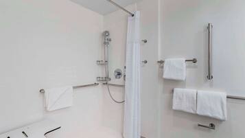 Een moderne badkamer met een douche, een handgreep en een handdoekhouder.