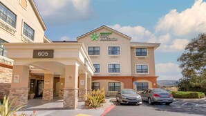 Ett hotell med en skylt där det står ”Extended Stay America” och siffran ”605” ovanför ingången.