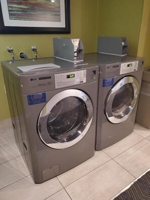 A pair of LG front-loading washing machines in a commercial setting.