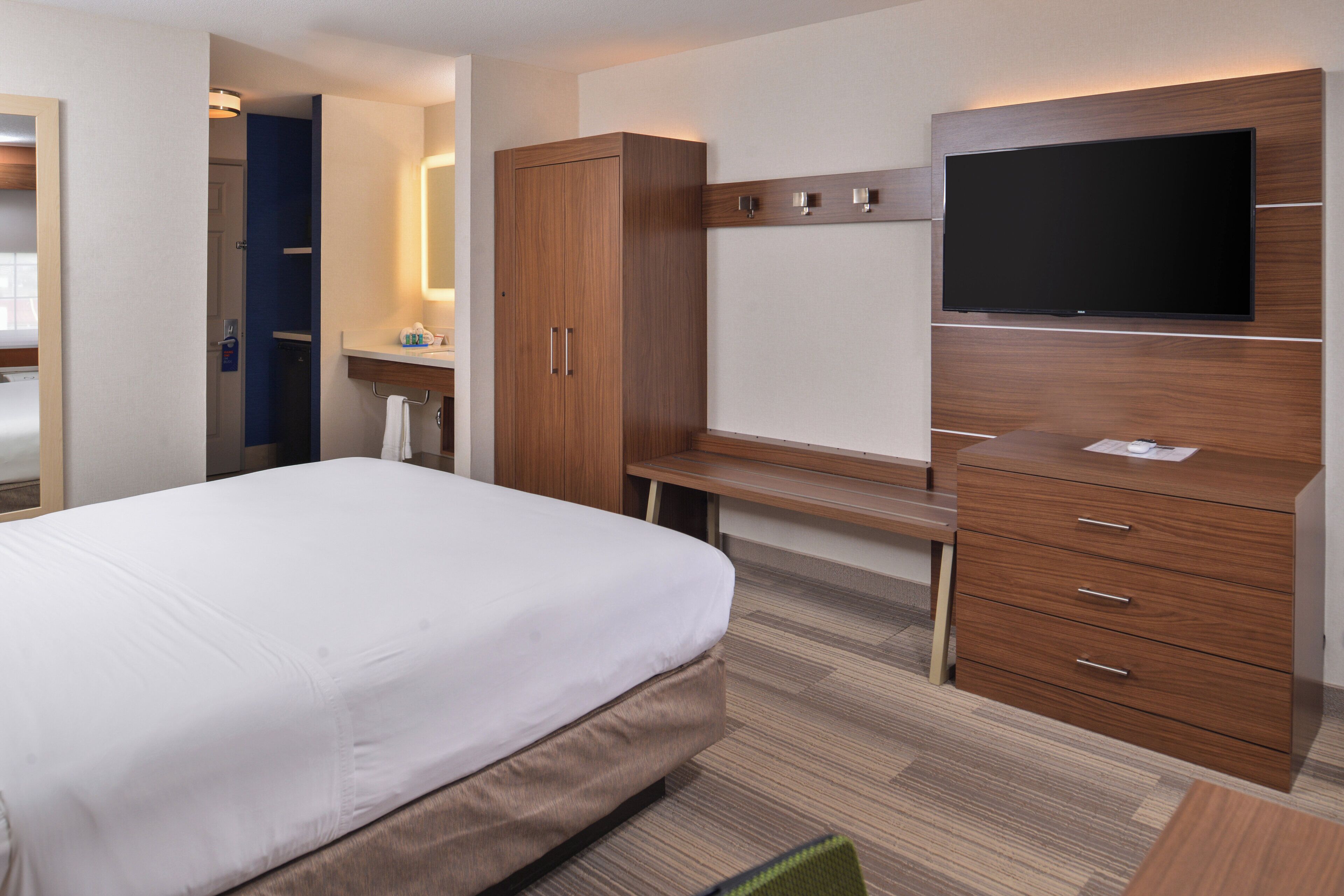 Une chambre d’hôtel équipée d’un lit, d’un bureau, d’une armoire et d’un téléviseur.