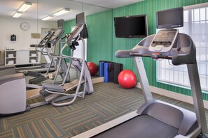A fitness center with treadmills, exercise balls, and a television screen. - Holiday Inn Express Westley by IHG (Westley)