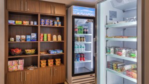 A refrigerated display case with various beverages and a freezer section with frozen food items. - Holiday Inn Express Westley by IHG (Westley)