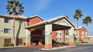 A hotel with a covered entrance, palm trees, and a clear blue sky. - Holiday Inn Express Westley by IHG (Westley)