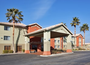 A hotel with a covered entrance, palm trees, and a clear blue sky. - Holiday Inn Express Westley by IHG (Westley)