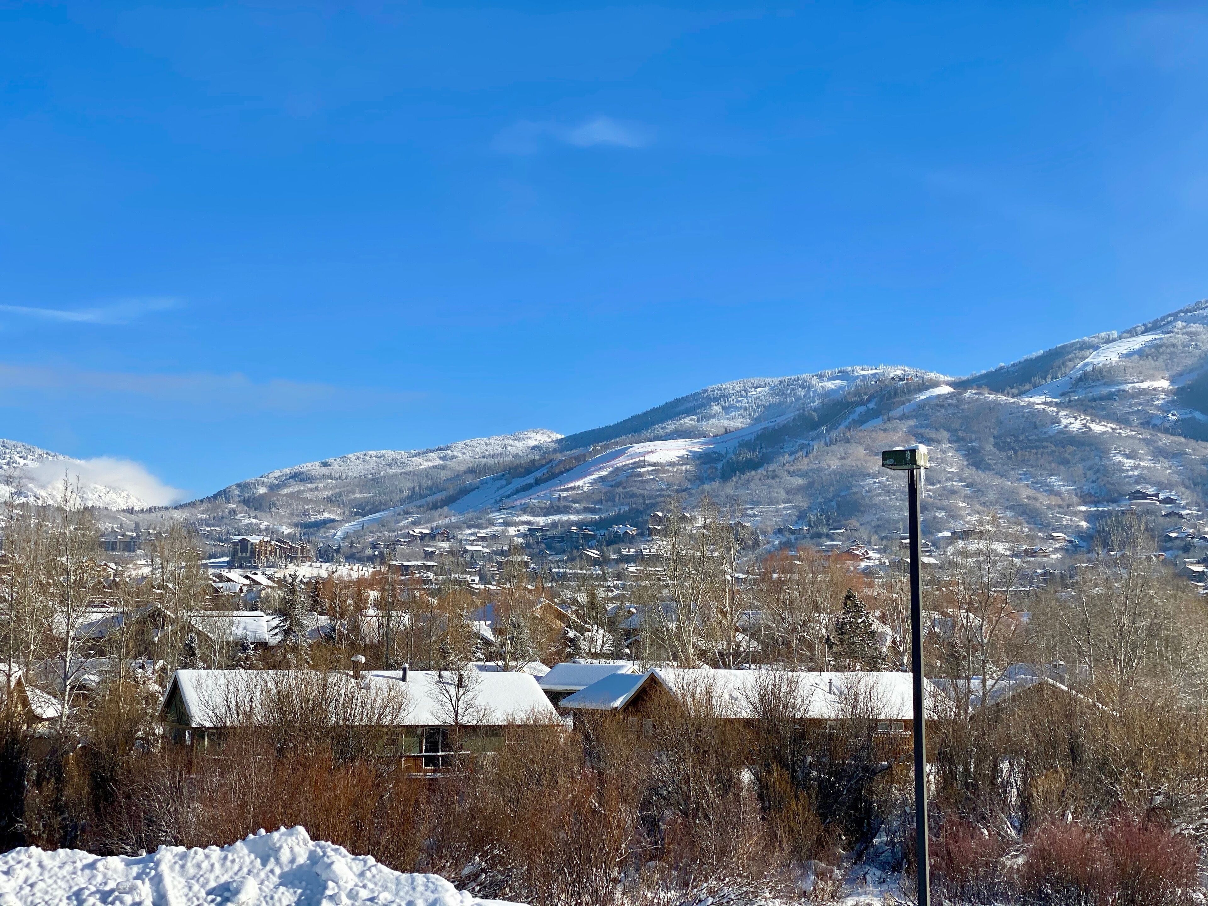 A snow-covered mountain landscape with buildings in the foreground.
