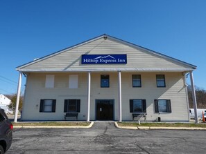 Un edificio de dos pisos con un letrero que dice Hilltop Express Inn.