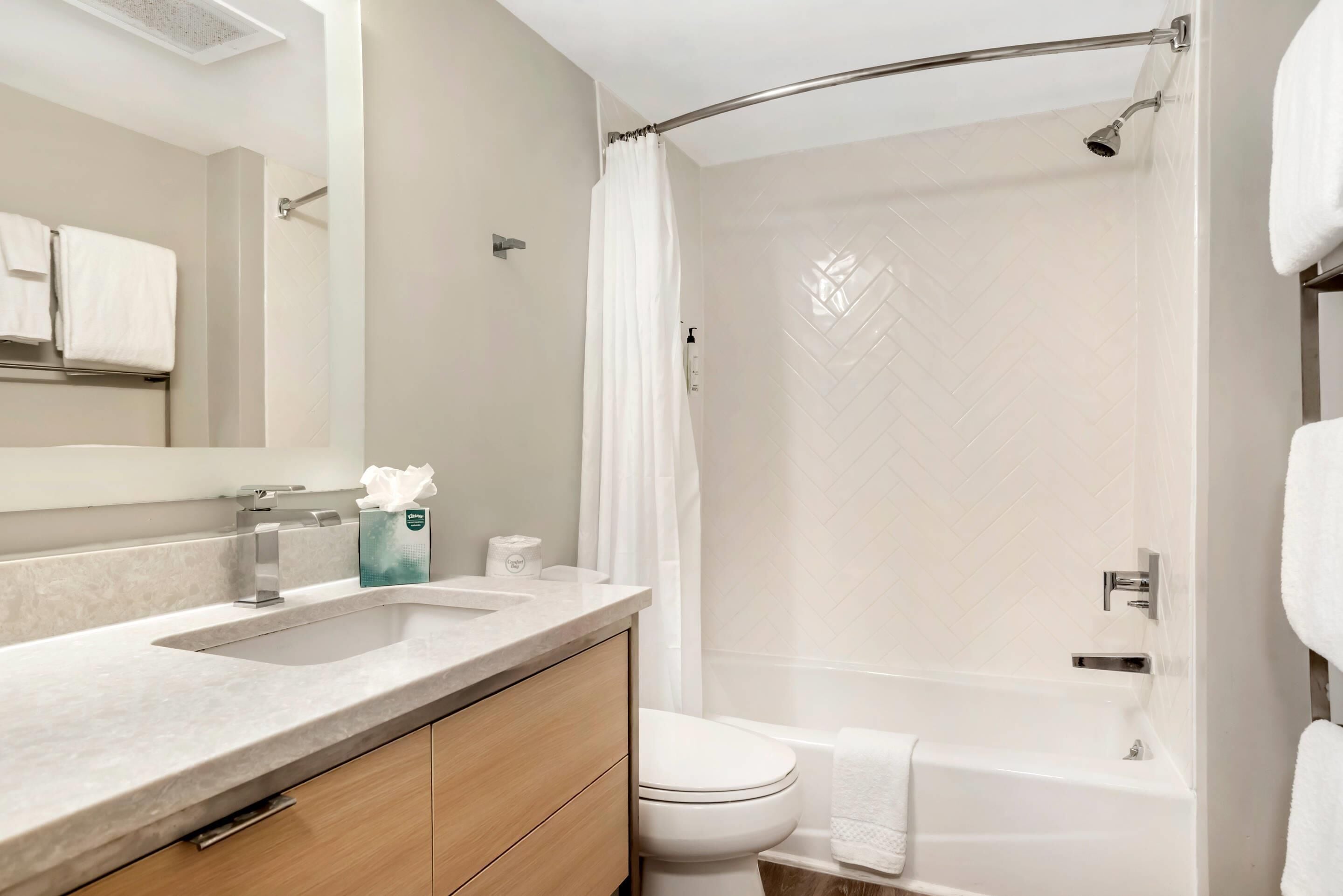 Une salle de bain moderne équipée d’une douche, de toilettes et d’un lavabo.
