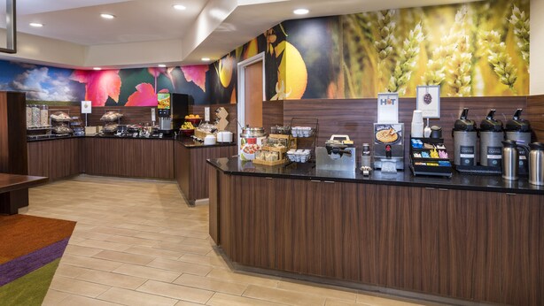 Un café moderne avec un comptoir, des machines à café et une fresque murale.