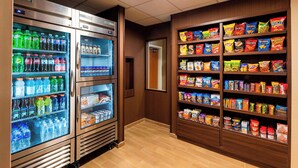 Un espace de vente proposant plusieurs distributeurs de boissons et des présentoirs de snacks.