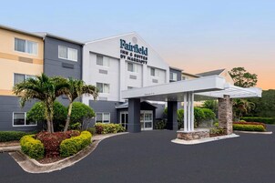 Un hotel Fairfield Inn & Suites by Marriott con entrada cubierta y jardín ajardinado.