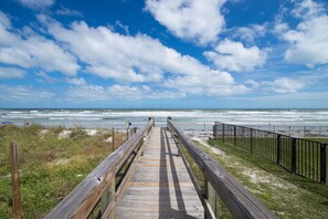 A wooden boardwalk leading to a beach with a clear sky and ocean view. - Coconut Palms Beach Resort II, an Ascend Collection Hotel (New Smyrna Beach)