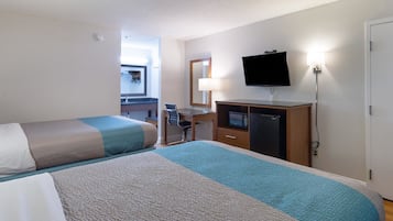 Une chambre d’hôtel avec deux lits, un bureau avec une chaise, une télévision et un four à micro-ondes.