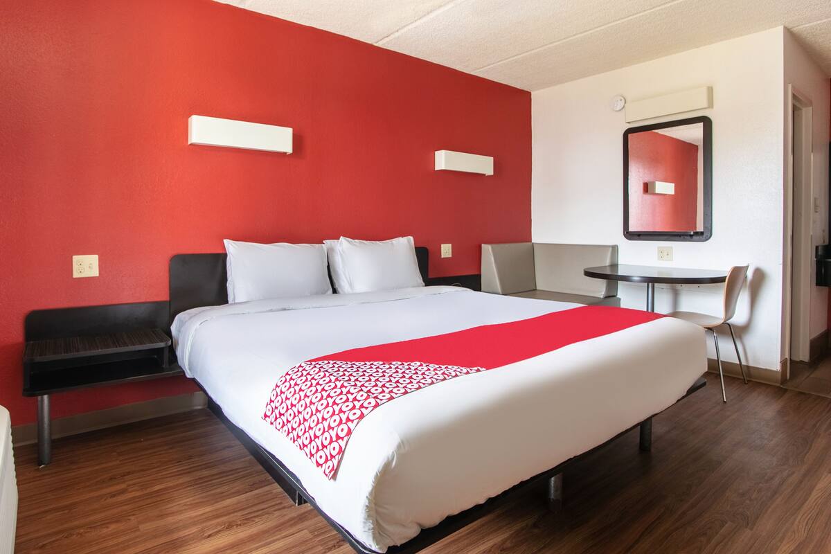 Une chambre d’hôtel avec un grand lit, un bureau et une chaise.