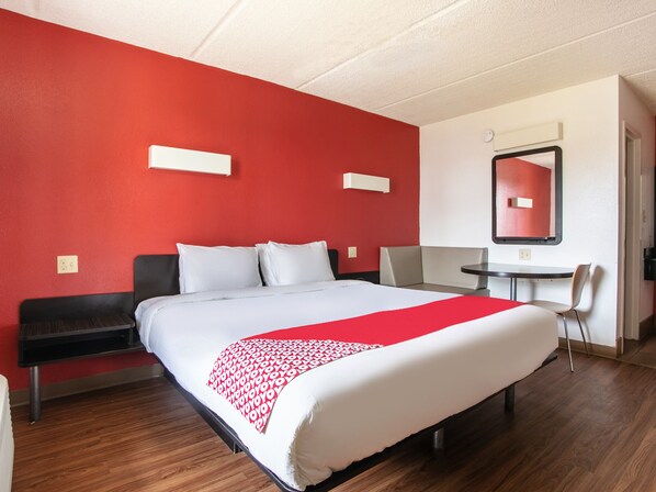 Ein Hotelzimmer mit einem großen Bett, einem Schreibtisch und einem Stuhl.