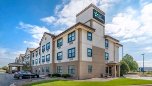 A multi-story hotel with a modern design, featuring a prominent sign for Stay America. - Extended Stay America Suites Chicago Romeoville Bollingbrook (Romeoville)