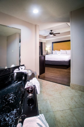 Relax in a stylish room with a large mirror, bathtub, and a comfortable bed with crisp linens.