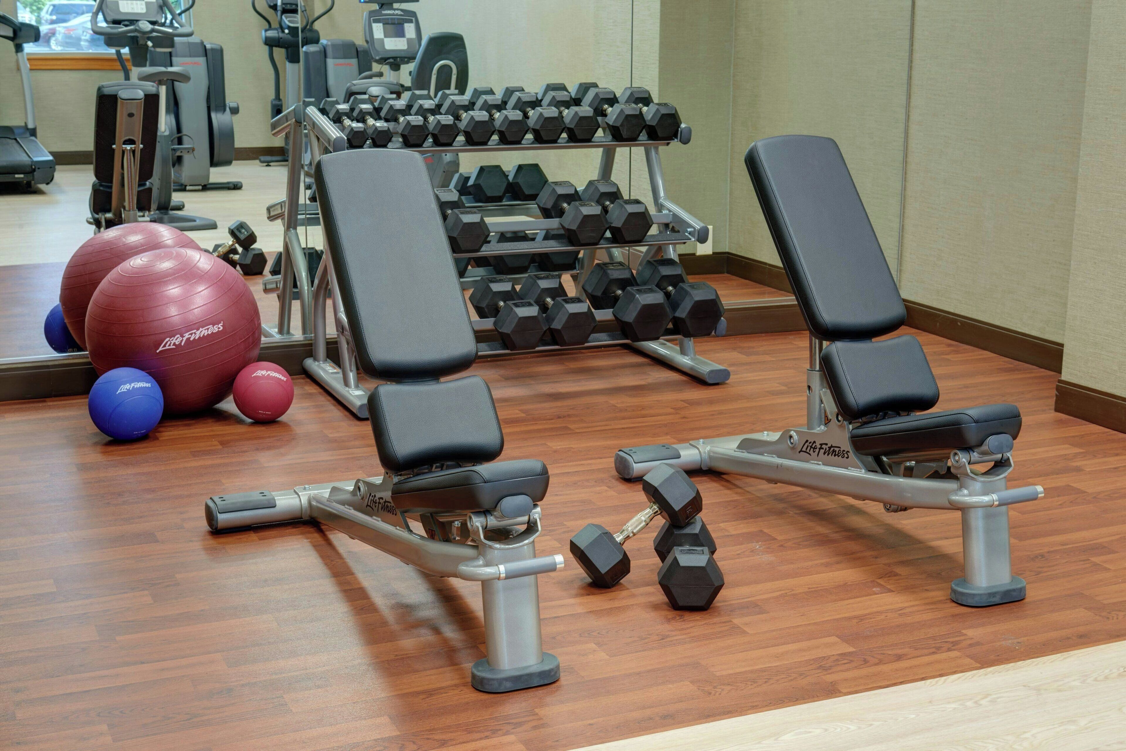 A gym with exercise equipment, including dumbbells and medicine balls.