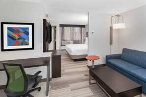 A hotel room with a bed, a desk, a chair, a sofa, a lamp, and a framed picture on the wall. - Holiday Inn Express Hotel & Suites South Portland by IHG (South Portland)