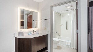 Une salle de bain moderne avec un meuble-lavabo, un miroir et un espace douche.