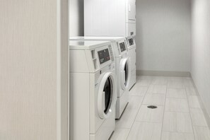A laundry room with three stacked washing machines and a dryer. - Holiday Inn Express Hotel & Suites South Portland by IHG (South Portland)