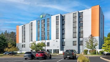 A Holiday Inn Express & Suites hotel with a parking lot and several vehicles.