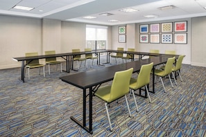 A conference room with a long table, green chairs, patterned carpet, and framed artwork on the walls. - Holiday Inn Express Hotel & Suites South Portland by IHG (South Portland)